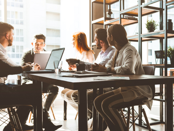 5 people sitting around a table having a meeting