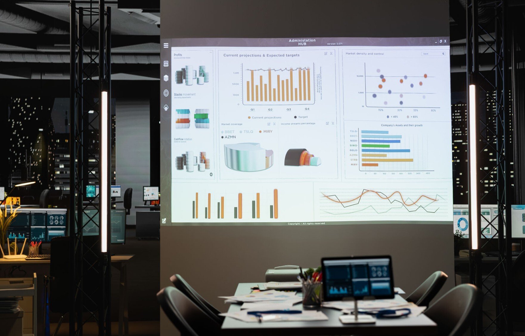 Office setting at night time with an empty table that has a projection above it of charts, data, bar graphs, and other charts
