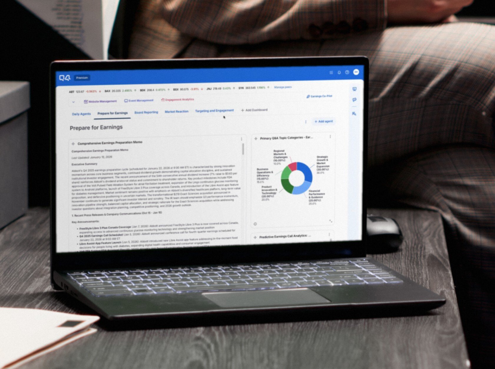 A laptop sitting open on a desk with a dashboard showing