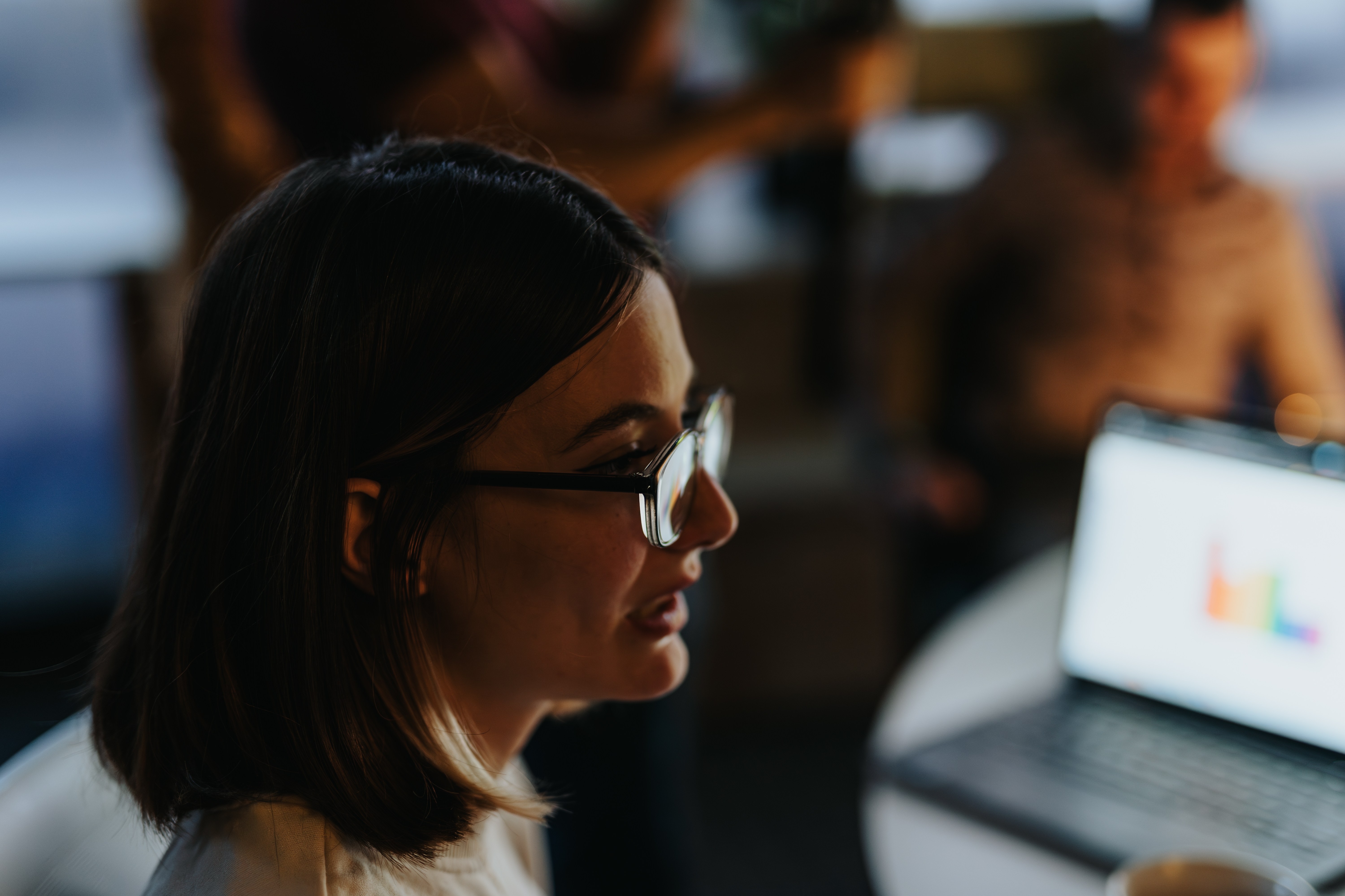 Woman with dark hair wearing glasses working at a computer
