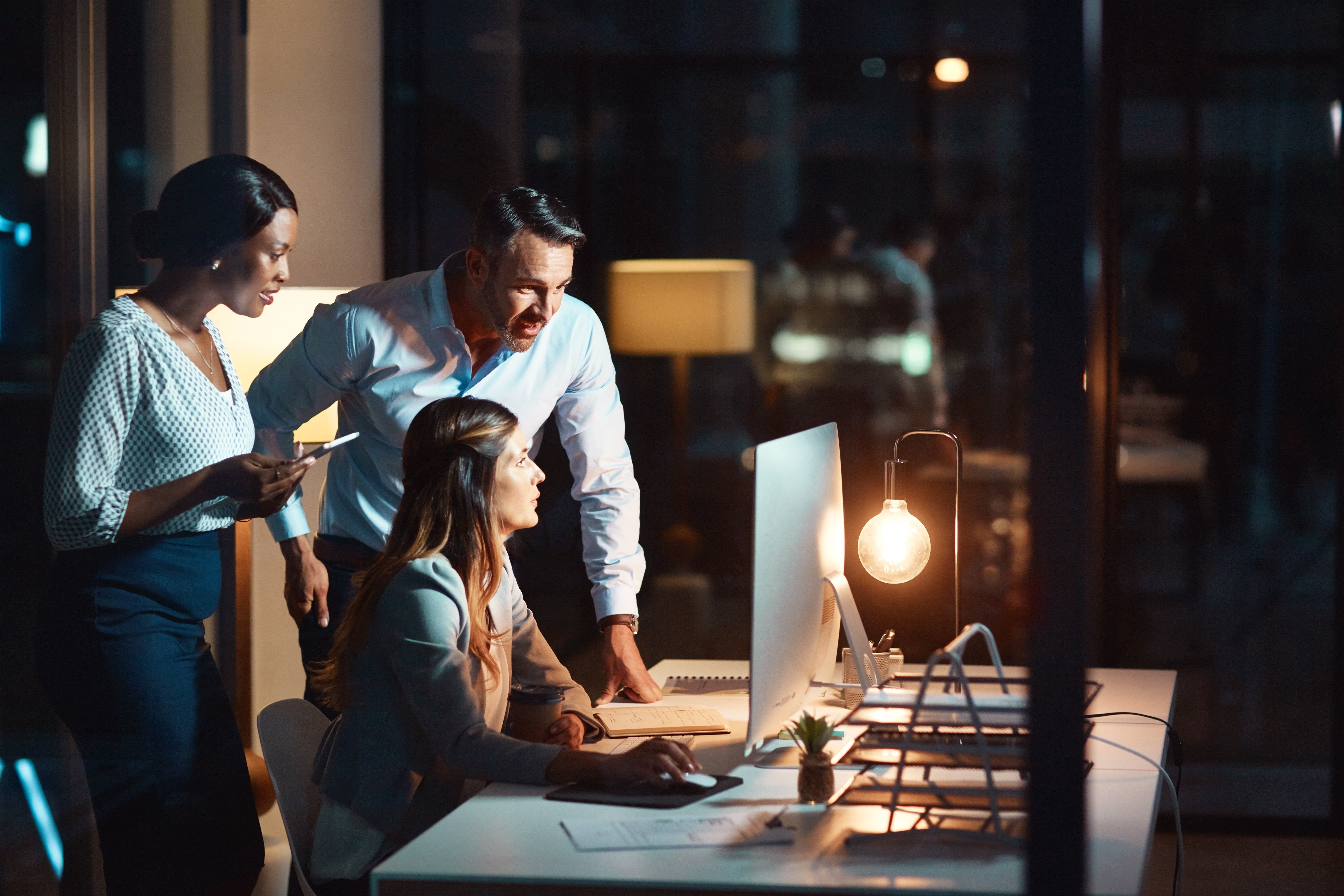 3 people circled around a desk working together
